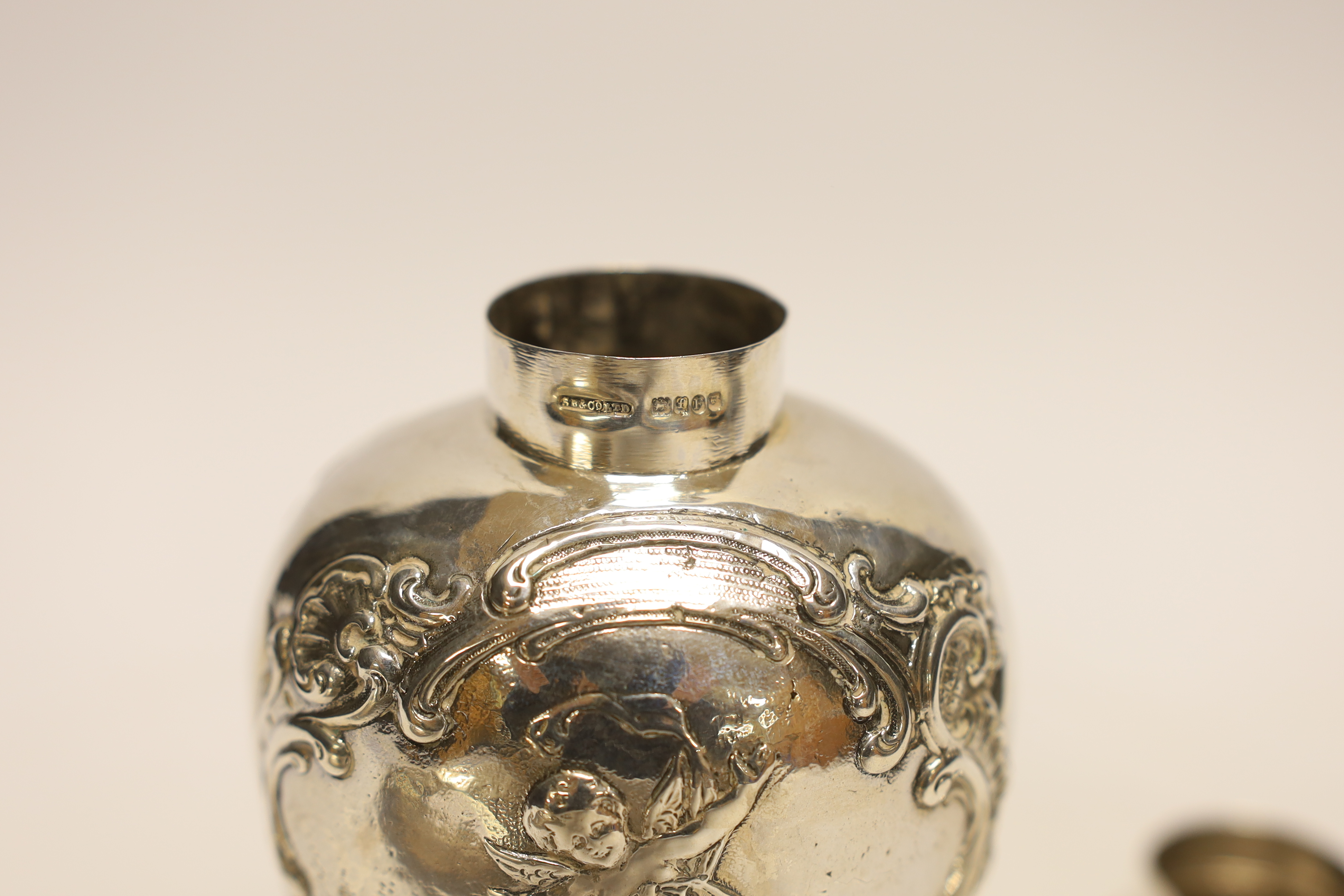 An Edwardian continental embossed silver tea caddy? and cover decorated with amorini, makers stamp to the base, import marks for London, 1902, height 15.8cm, 7.1oz.